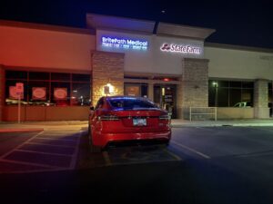 Red car parked outside medical office